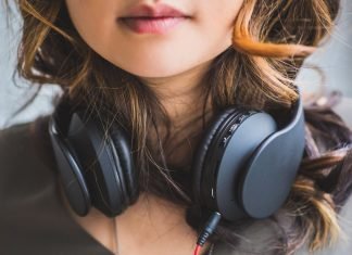 Brug denne app i stedet for YouTubes musikhjemmeside En pige med sorte hovedtelefoner rundt om halsen.