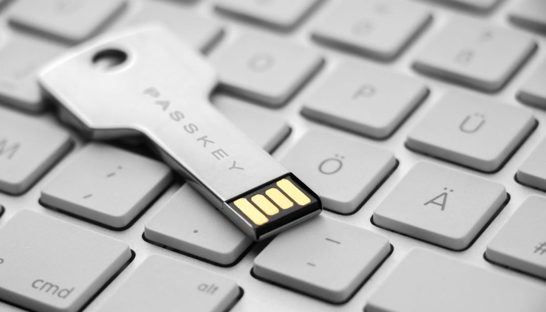 passkeys Et USB-drev i form af en nøgle med teksten "PASSKEY" indgraveret. Drevet ligger på et stilrent hvidt tastatur.