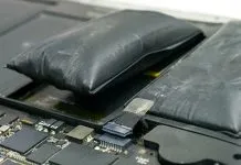 To oppustede, sorte batterier ligger på en grå, slidt overflade. Batterierne er tydeligt hævede og ser deformerede ud, hvilket indikerer en mulig fejlfunktion eller overopladning.