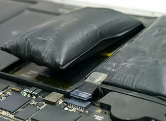 To oppustede, sorte batterier ligger på en grå, slidt overflade. Batterierne er tydeligt hævede og ser deformerede ud, hvilket indikerer en mulig fejlfunktion eller overopladning.