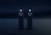To sorte, slanke hi-fi-højttalere med hvide ringe omkring enhederne står side om side i et mørkt rum.
