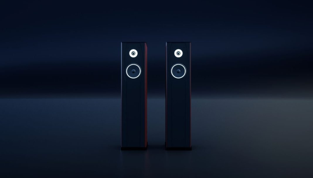 To sorte, slanke hi-fi-højttalere med hvide ringe omkring enhederne står side om side i et mørkt rum.