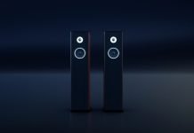 To sorte, slanke hi-fi-højttalere med hvide ringe omkring enhederne står side om side i et mørkt rum.