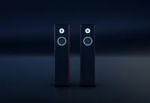 To sorte, slanke hi-fi-højttalere med hvide ringe omkring enhederne står side om side i et mørkt rum.