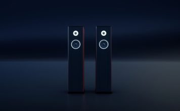 To sorte, slanke hi-fi-højttalere med hvide ringe omkring enhederne står side om side i et mørkt rum.